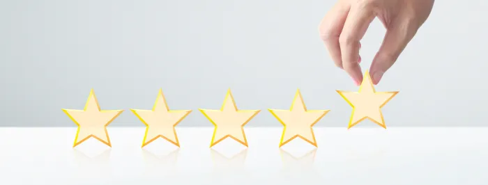 Ręka ustawiająca piątą gwiazdkę w pięciogwiazdkowym rankingu